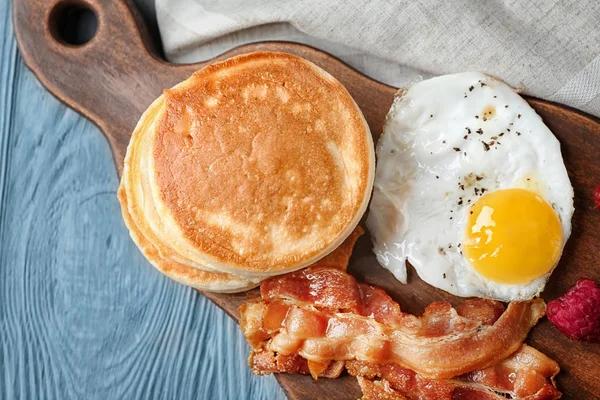 Lezzetli kek, kızarmış domuz pastırması ve yumurta ahşap masa üzerinde kurulu