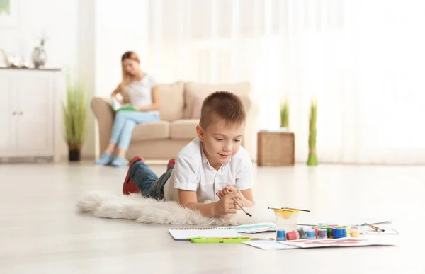 Foto bonito da pintura do menino na folha de papel, dentro de casa — Fotografia de Stock