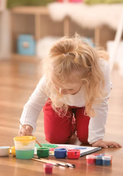 Menina bonito pintura imagem na folha de papel, dentro de casa — Fotografia de Stock