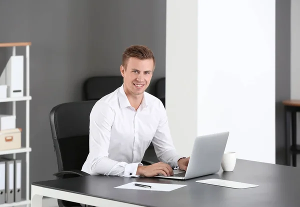 Hombre guapo con portátil en la oficina —  Fotos de Stock