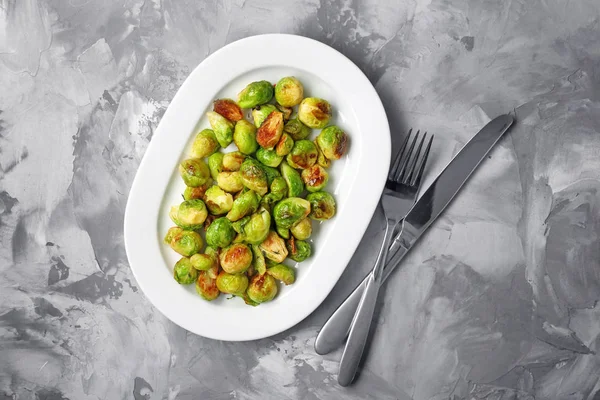 Plaat met geroosterde brussel spruiten op tafel — Stockfoto