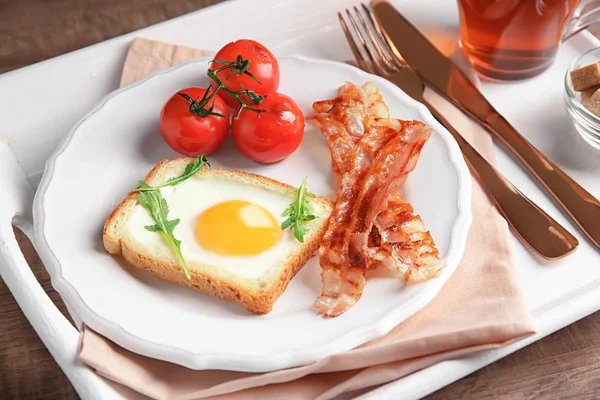 Tabak kızarmış yumurta, pastırma ve tepsi üzerinde domates ile