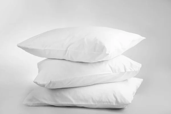 Travesseiros macios em branco no fundo claro — Fotografia de Stock