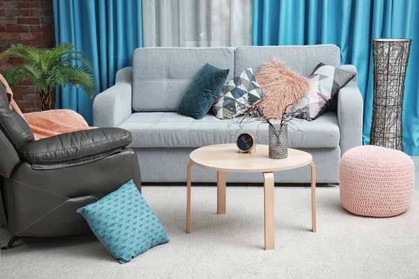 Vardagsrum inredning med grå soffa och läderfåtölj — Stockfoto