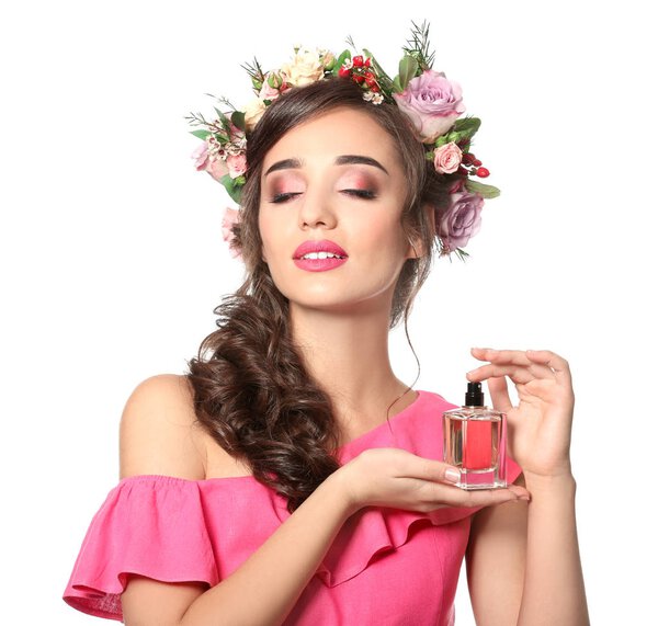 Красивая молодая женщина с бутылкой цветочных духов на белом фоне
