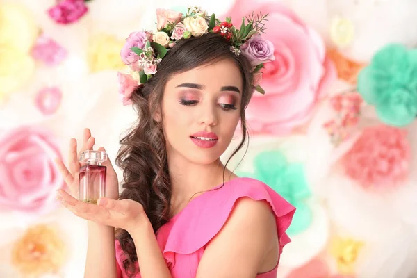 Hermosa mujer joven con botella de perfume floral sobre fondo de color — Foto de Stock