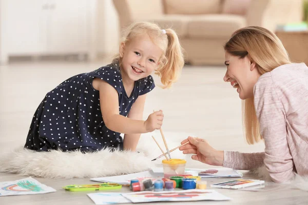 Madre con linda chica pintura cuadro en hoja de papel, en el interior —  Fotos de Stock