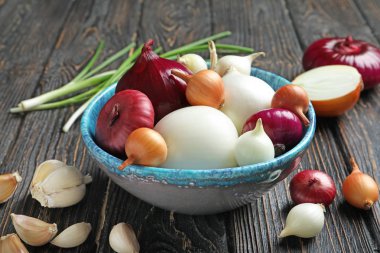 Ahşap masa üzerinde farklı soğanlı kase