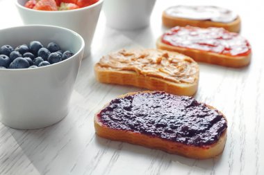 Reçel ve açık renkli fıstık ezmesi ile ekmek dilimleri