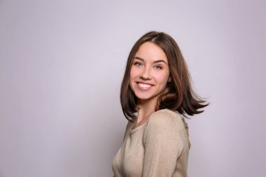 Işık arka plan üzerinde gülümseyen güzel kadın