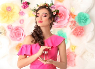 Renk arka plan üzerinde çiçek parfüm şişe güzel genç kadın