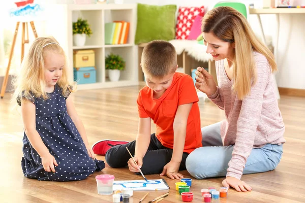 Mother with cute children painting picture, indoors — Stock Photo, Image