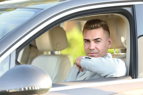 Мужчина в формальной одежде на водительском сидении автомобиля — стоковое фото