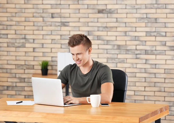 Schöner Mann mit Laptop im Büro — Stockfoto