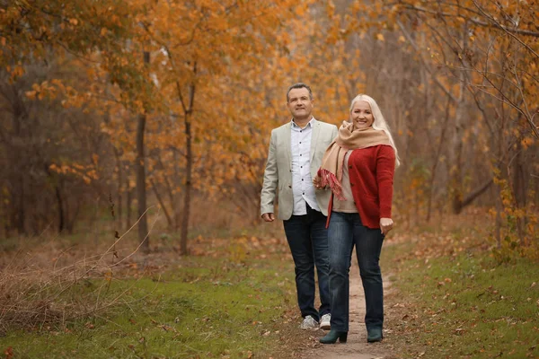 Pareja madura caminando en el parque en el día de otoño — Foto de Stock