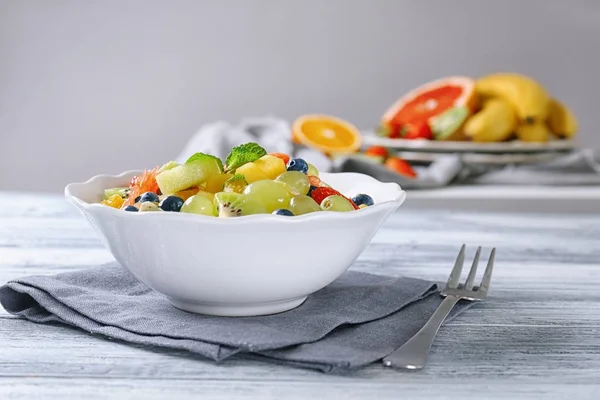 Bowl with delicious fruit salad on table — Stock Photo, Image