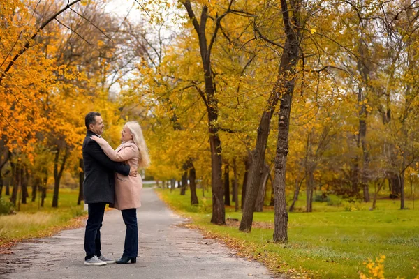 Pareja madura caminando en el parque en el día de otoño — Foto de Stock