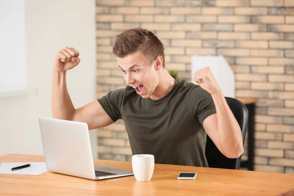 Emotionele man met laptop in kantoor — Stockfoto