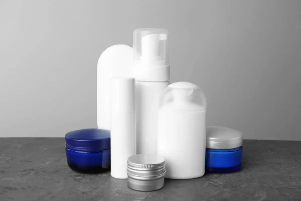 Conjunto de productos para el cuidado corporal sobre fondo gris —  Fotos de Stock