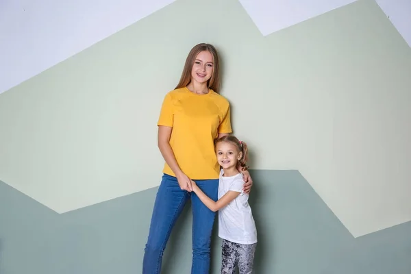 Mère heureuse et sa fille contre le mur de couleur dans la chambre des enfants — Photo