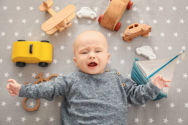 Schattige jongen met speelgoed Over beddelaken — Stockfoto