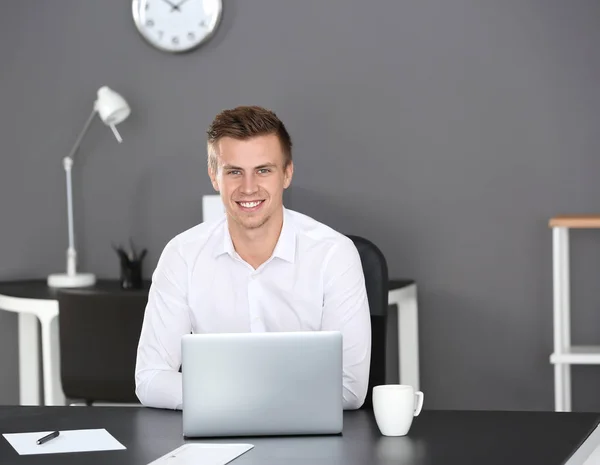 Handsome man with laptop in office — Stock Photo, Image