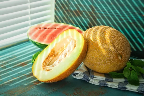 Lekker vers meloenen en watermeloen op houten tafel — Stockfoto