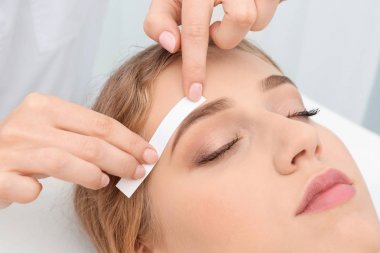 Güzellik salonunda kaş düzeltme ameliyatı olan genç bir kadın.