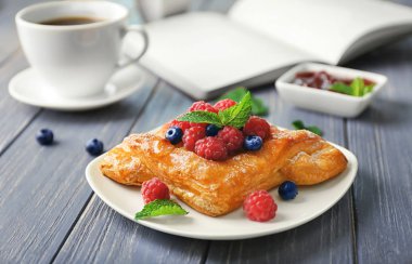 Ahşap masa üzerinde nefis berry puf böreği ile plaka