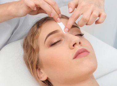 Güzellik salonunda kaş düzeltme ameliyatı olan genç bir kadın.