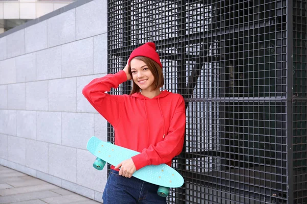 Hipster meisje met skateboard buitenshuis — Stockfoto