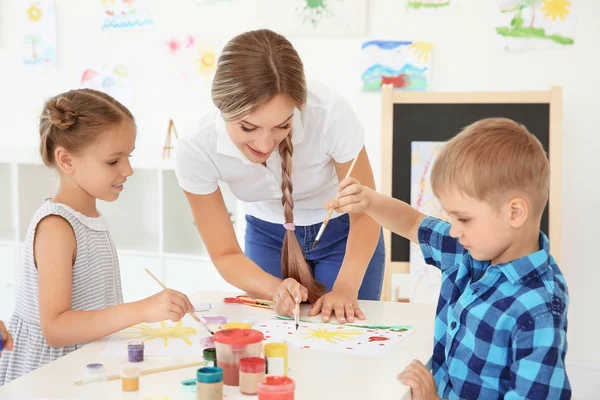 Діти з учителем на уроці малювання в класі — стокове фото