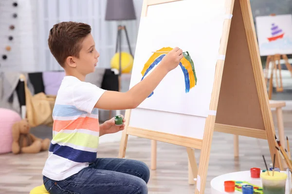 Маленький мальчик рисует радугу дома — стоковое фото
