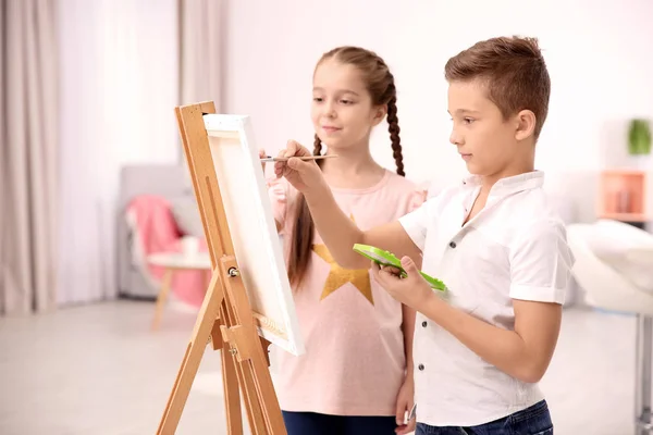 Menina com irmão pintando em casa — Fotografia de Stock