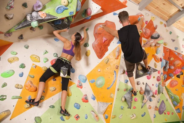Young couple exercising in climbing gym — Stock Photo, Image
