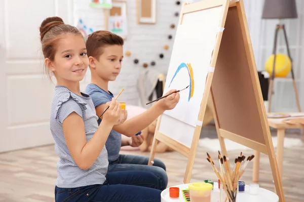 Meisje met broer thuis schilderen — Stockfoto