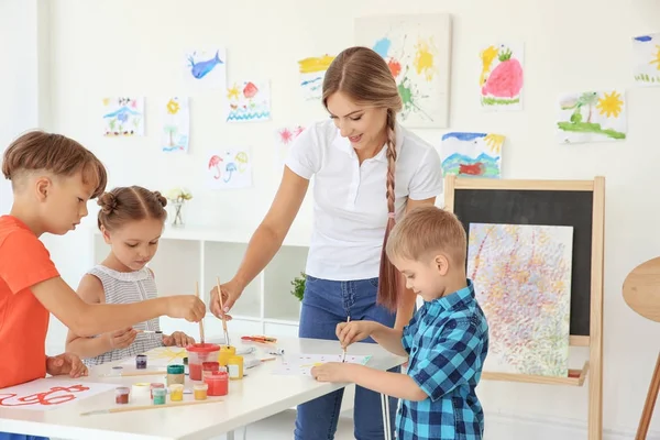 Barn med lärare på målning lektion i klassrummet — Stockfoto