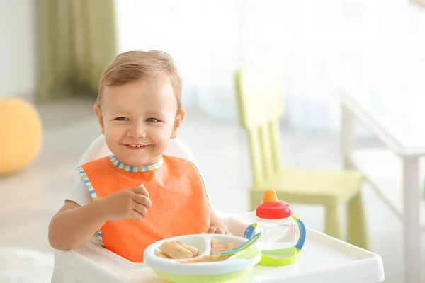 Adorable baby sitting in highchair at home — Stock Photo, Image