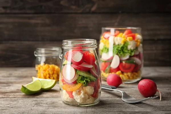 Delicious vegetable salad in jar on table