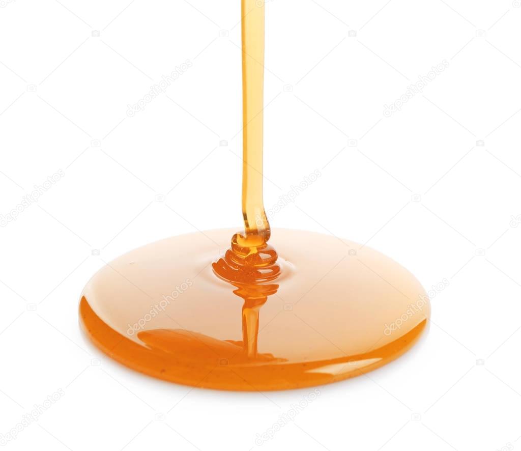 Sweet honey pouring on white background