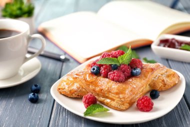 Ahşap masa üzerinde nefis berry puf böreği ile plaka