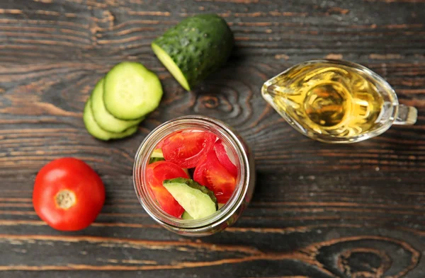 Delicious vegetable salad in jar on wooden table