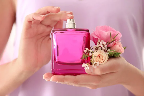 Beautiful young woman with bottle of floral perfume, closeup — Stock Photo, Image