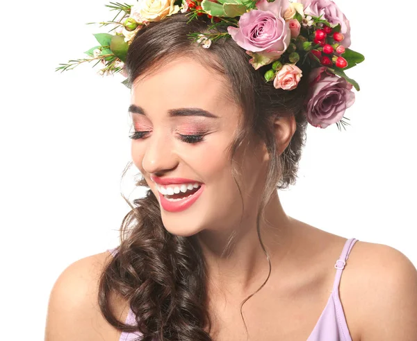 Bella giovane donna con corona di fiori su sfondo bianco — Foto Stock