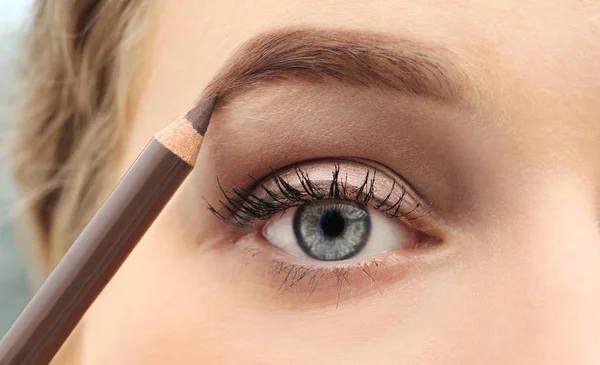 Junge Frau korrigiert Augenbrauenform mit Bleistift, Nahaufnahme — Stockfoto
