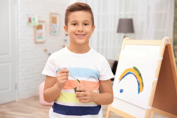 Kleine jongen schilderij regenboog thuis — Stockfoto