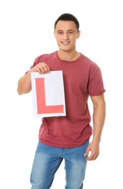 Beyaz arka plan üzerinde öğrenci sürücü işaret tutan genç adam