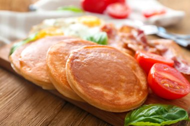 Lezzetli gözleme, domates ve ahşap masa üzerinde kızarmış domuz pastırması ile kurulu