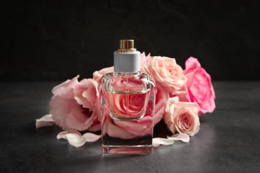 Çiçekler koyu arka plan üzerinde parfüm şişe