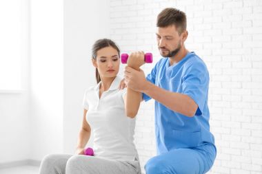 Fizyoterapist klinikte genç bayan hasta ile çalışma